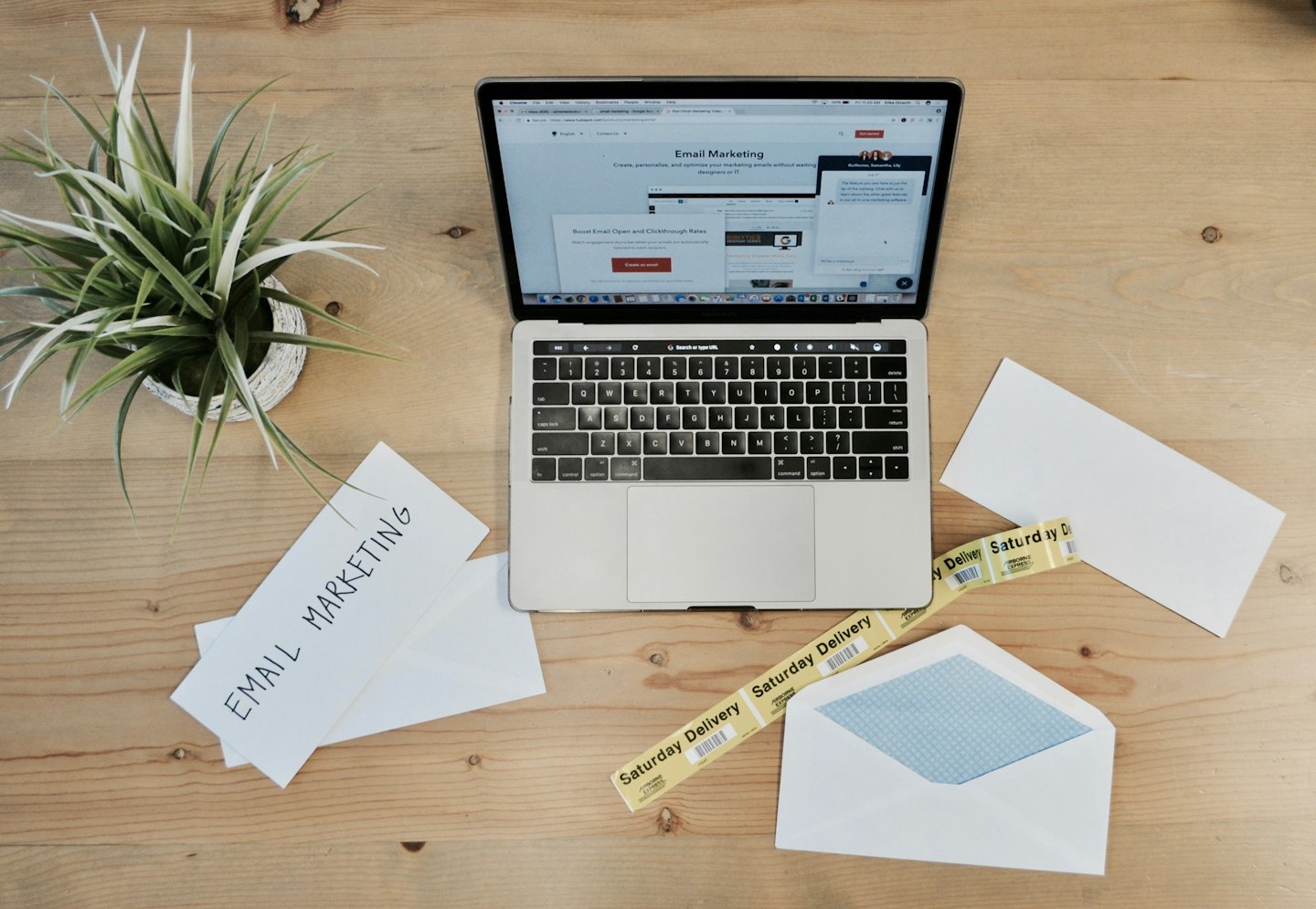 Portátil abierto en una web de email marketing sobre un escritorio de madera.