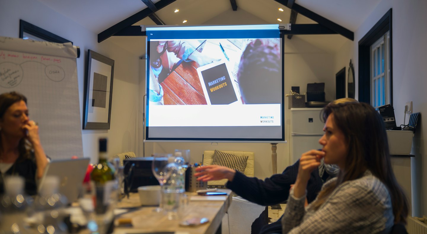 Profesionales de negocios asisten a un taller de marketing en una sala de reuniones.